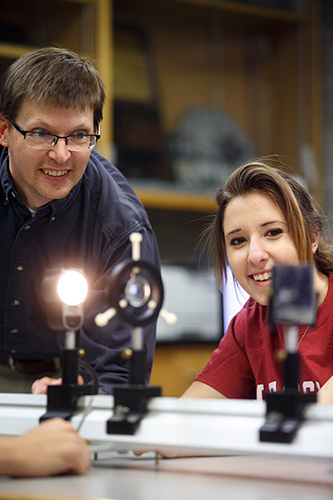 A professor and student observing the outcomes of a light ray experiment.