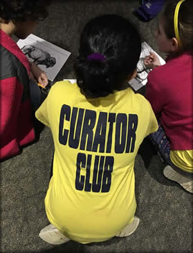 A child wearing a curator club tee shirt.