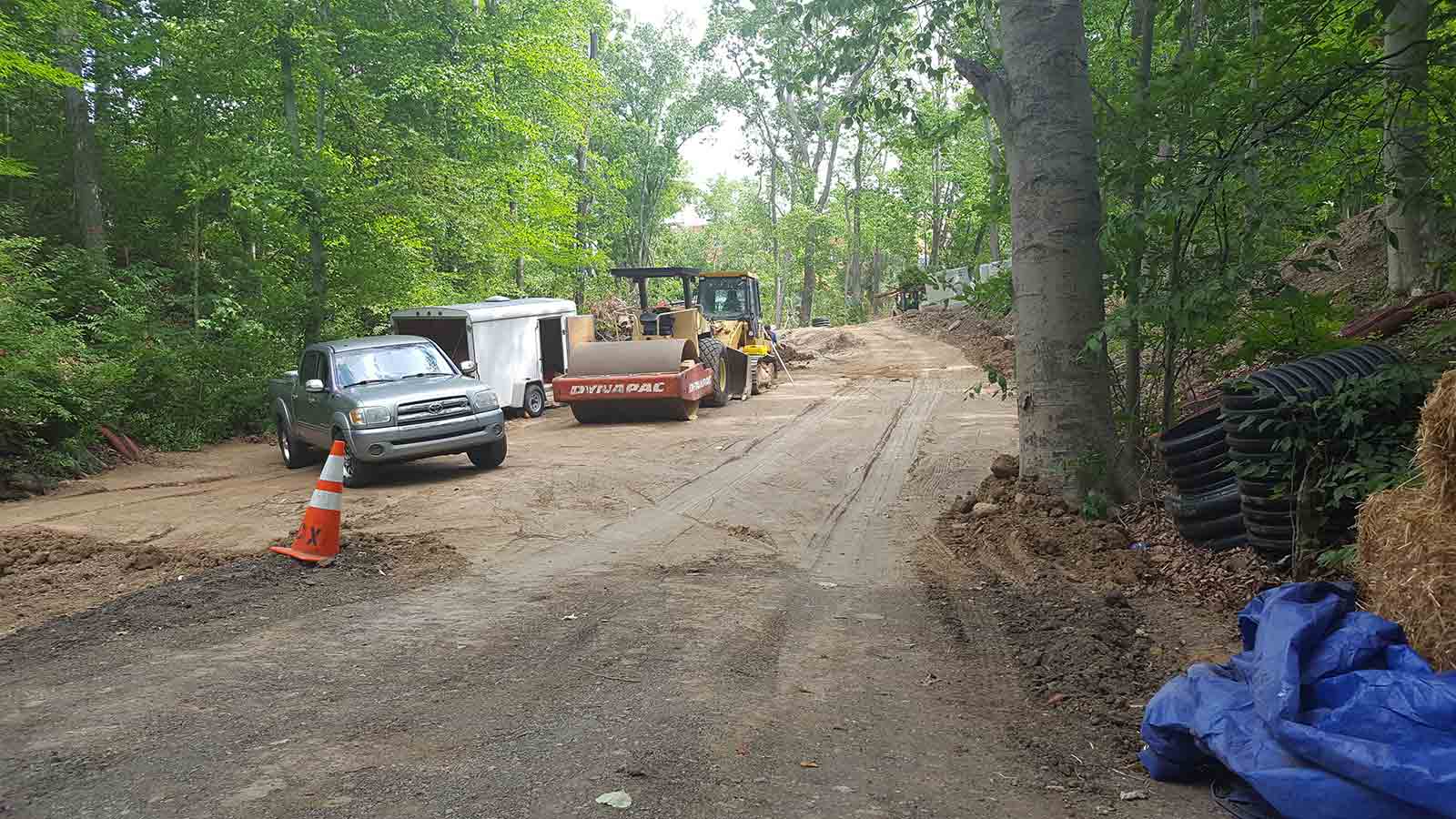 Construction vehicles parked by ravine restoration site.