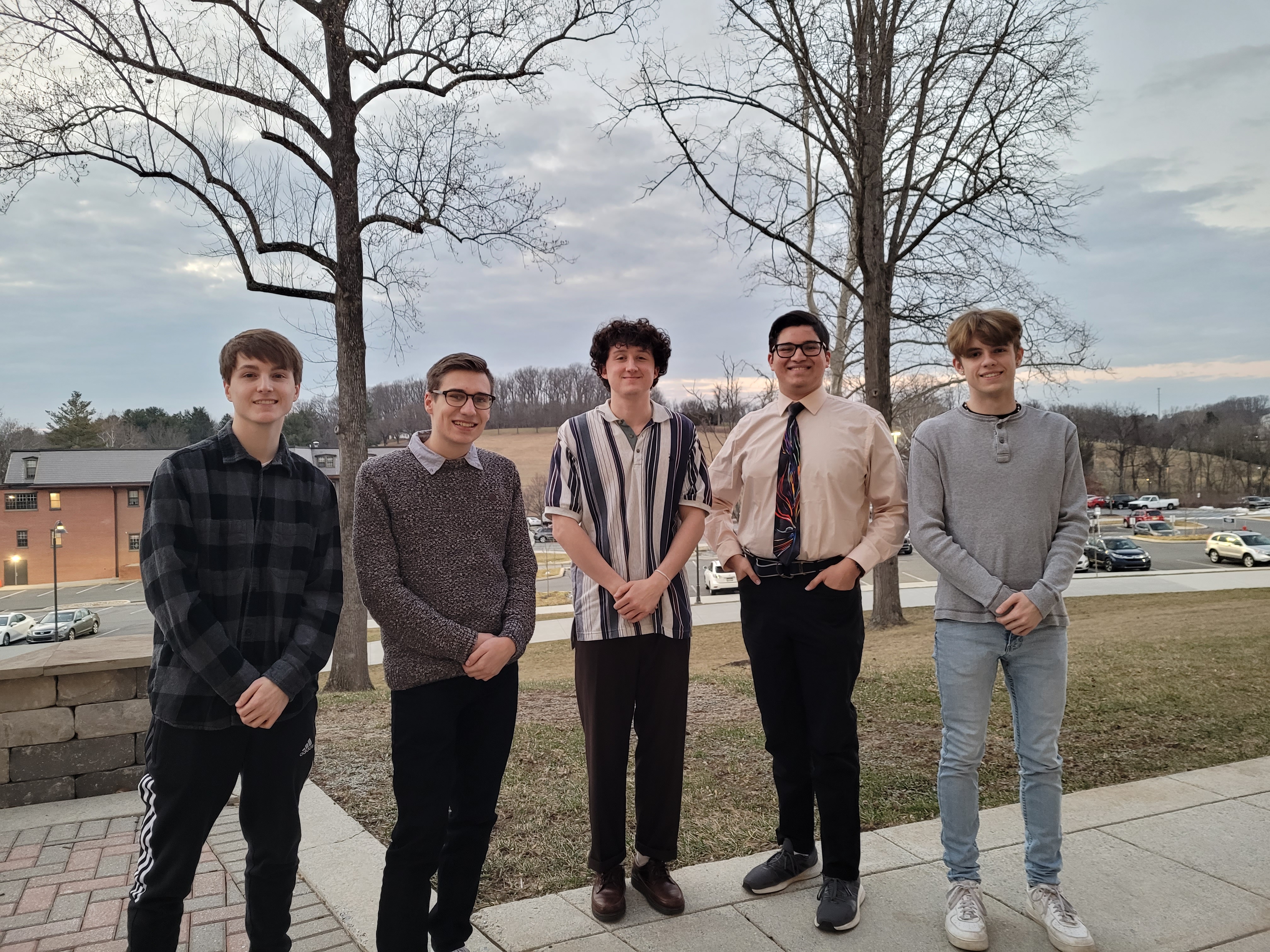 Five student fellows stand outside