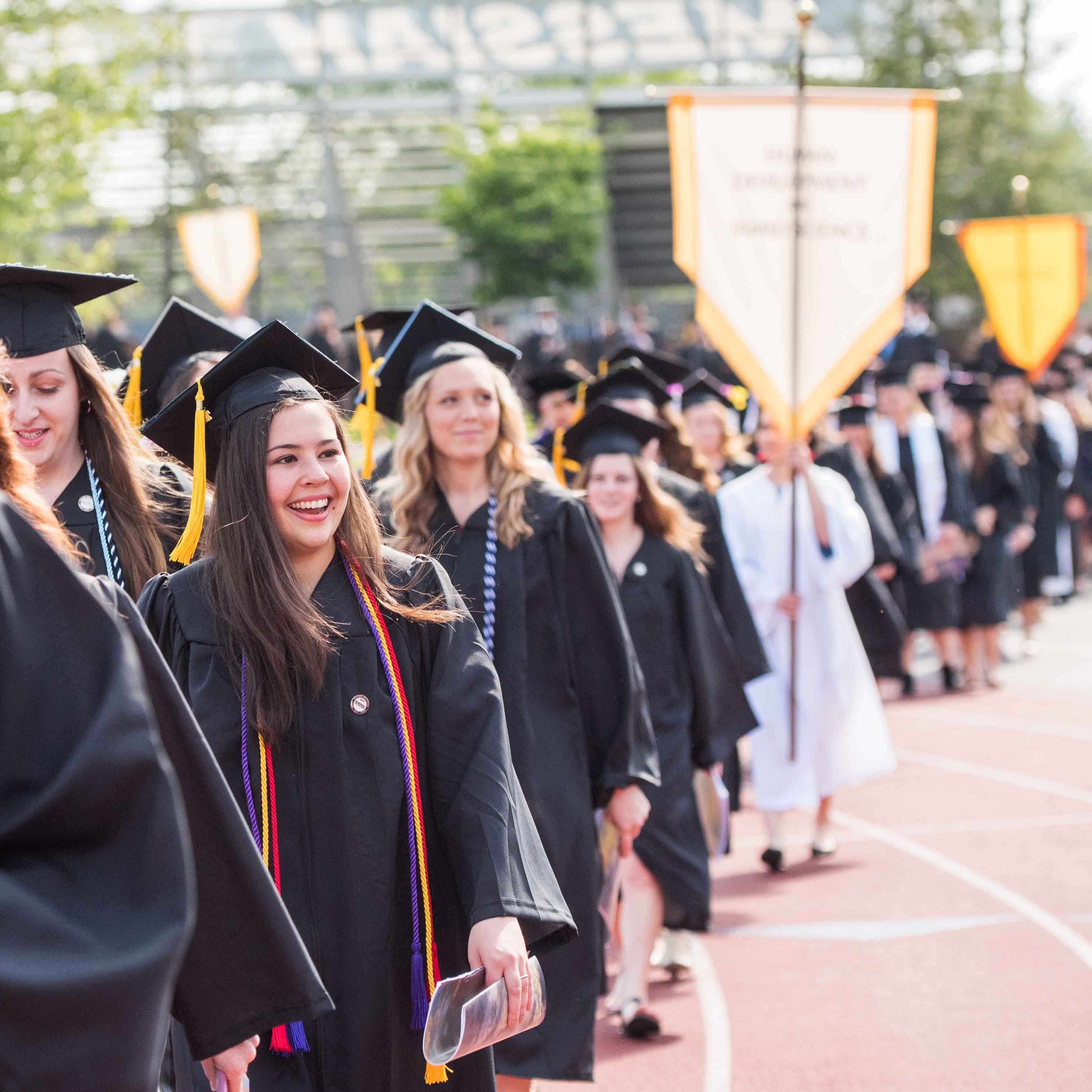 Line of grads walking onto field during Commencement ceremony 2019