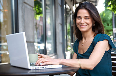 Young woman at laptop computer sitting outside working