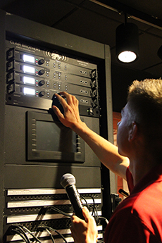 A male student adjusting volume levels of the audio system.