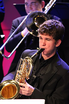 A male student playing a saxophone.