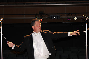 A conductor passionately conducting his orchestra.
