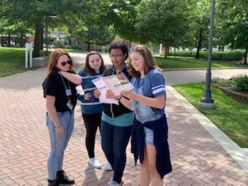 four students outside working on campus scavenger hunt.