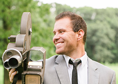 Communications alumni, Jonathan Stutzman, holding a vintage film camera.