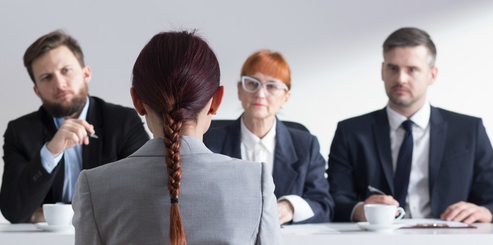 Three employers interviewing an an applicant.