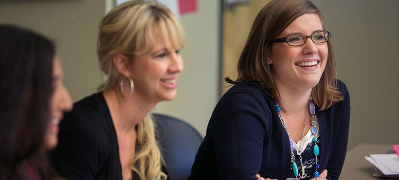 Two smiling female students in class