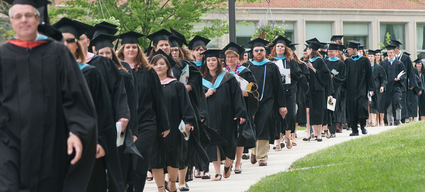 Financial Aid for Graduate Programs Graduating seniors walking with their gowns and caps on.jpg