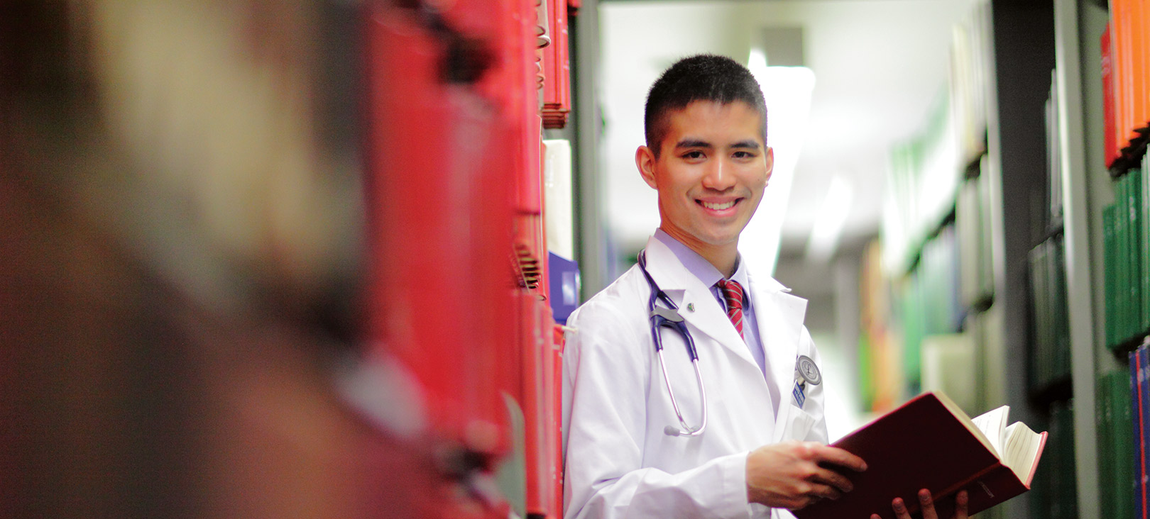 Pre-Health Professions Advising Biochemistry student wearing a stethoscope and holding a book.jpg