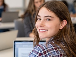Female student loooking over shoulder and smiling