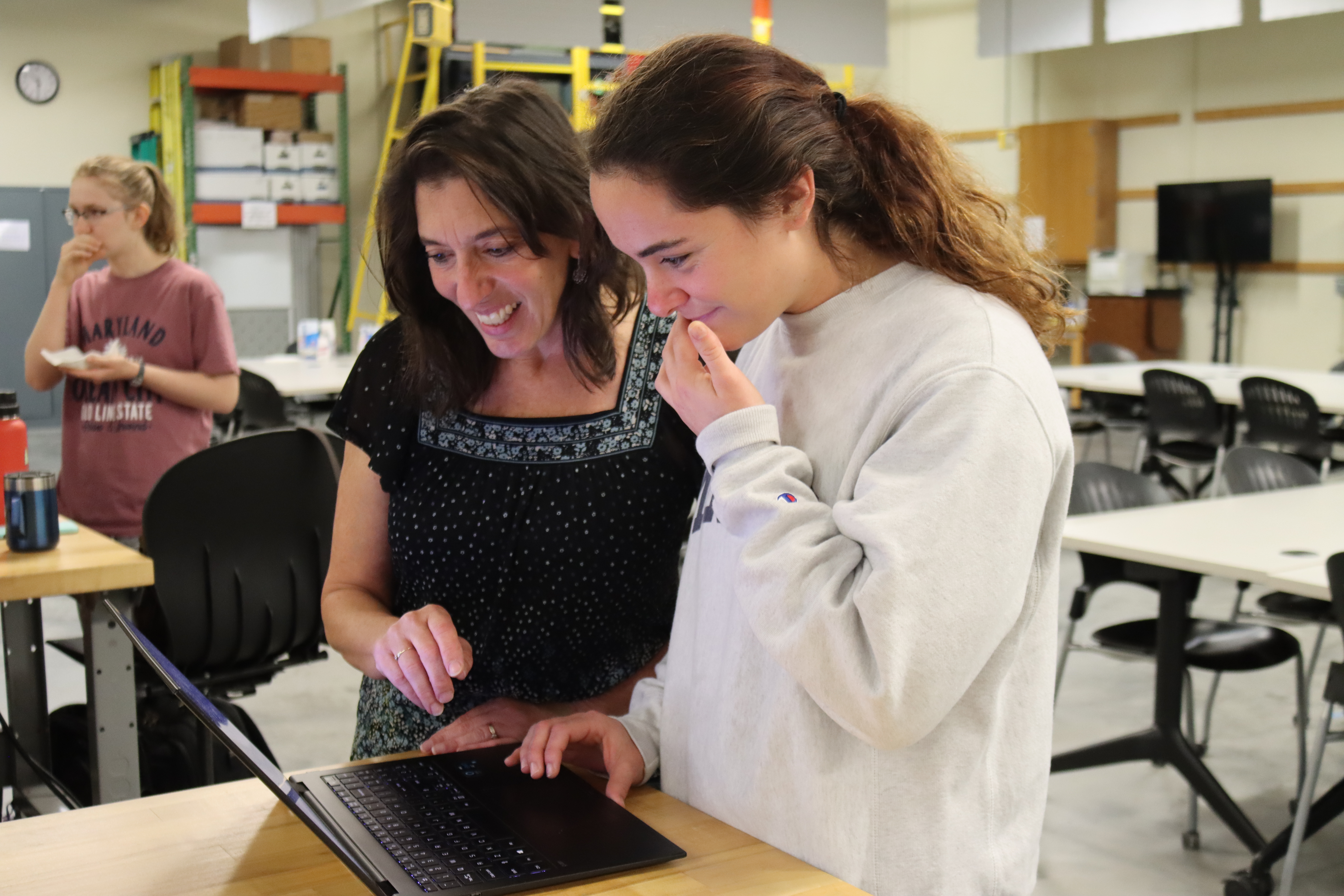Michelle Lockwood looking at a computer with student
