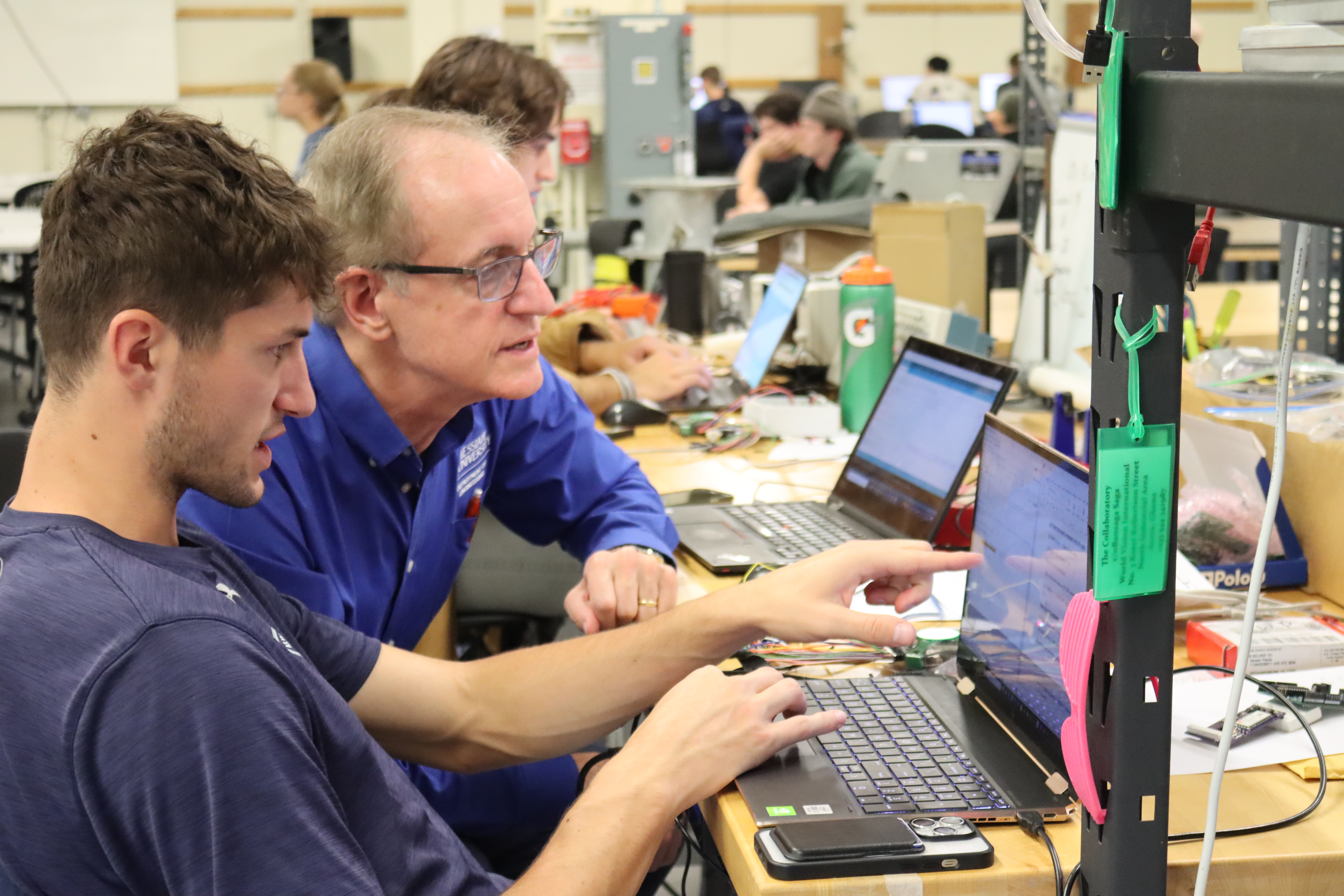 Randy Fish looking at computer with student