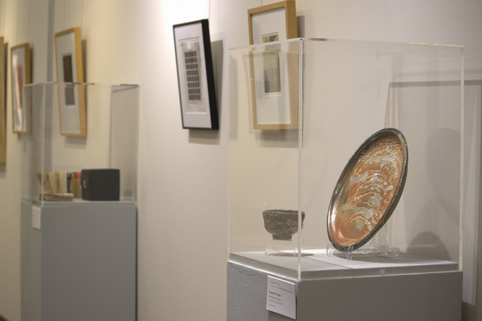 Ceramic plate next to wall of prints.