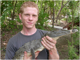 Male student holding an American crocodile