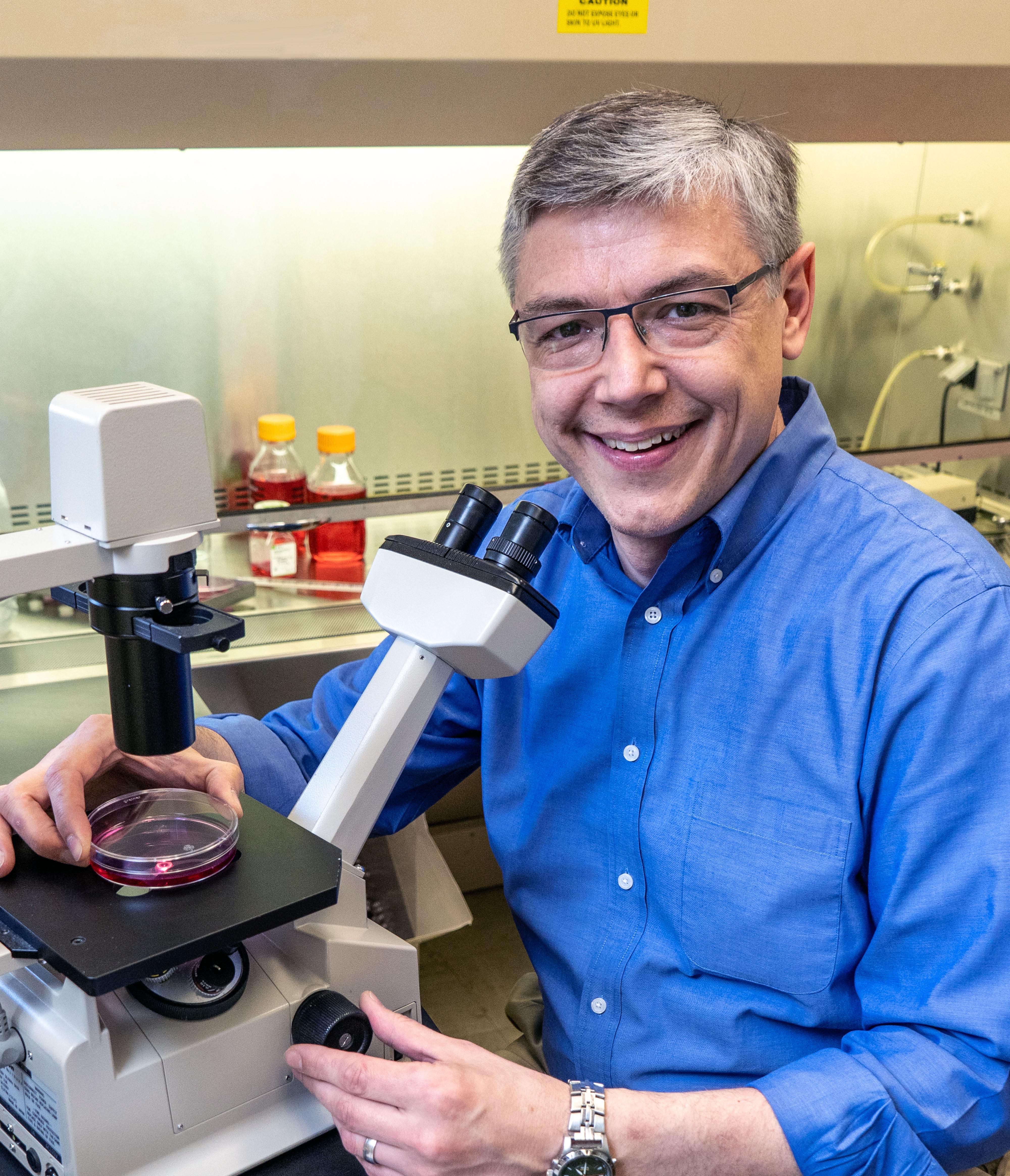 Portrait of John Harms with his microscope 
