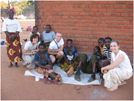 Students sitting with a group of children