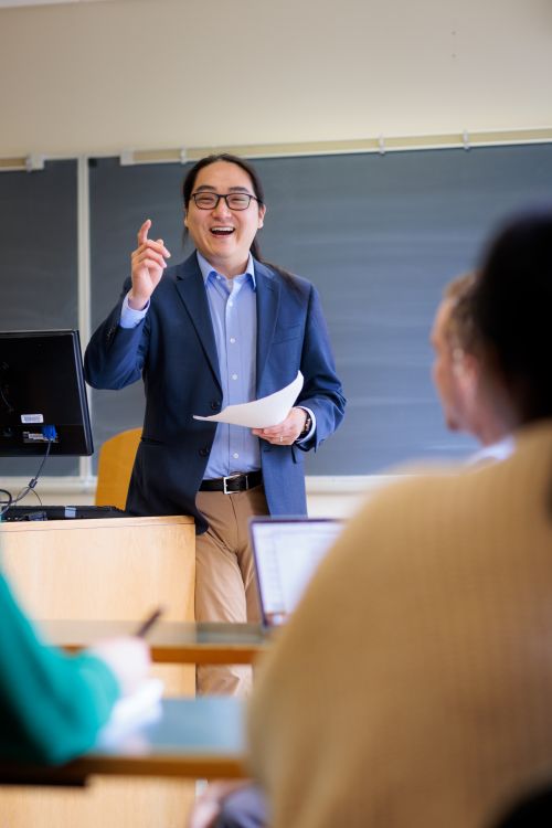 A professor standing in front of a class room