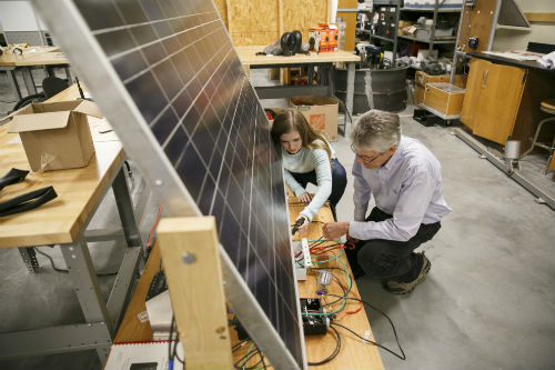 A professor and student work on a project in an engineering lab.