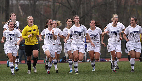 Messiah University women's soccer team jogging on the field.