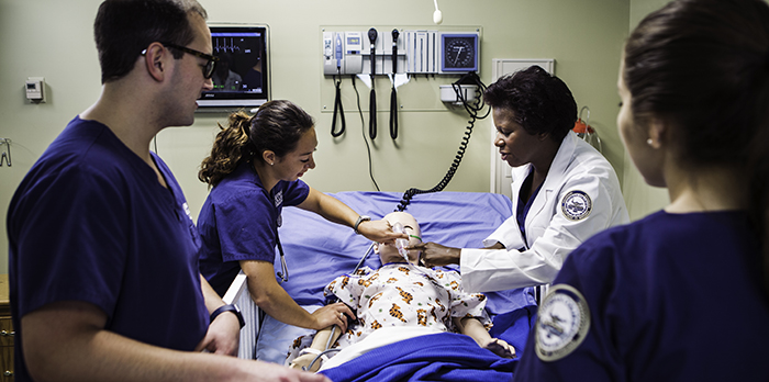 Nursing students work on a simulated patient in a lab