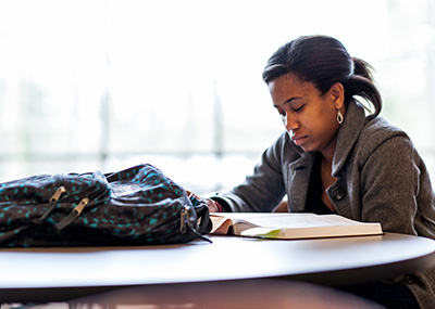 An African American student studying at the Boyer Atrium.
