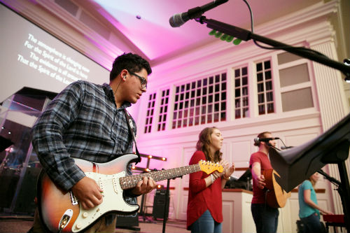 Students in Messiah's worship band sing at Powerhouse.