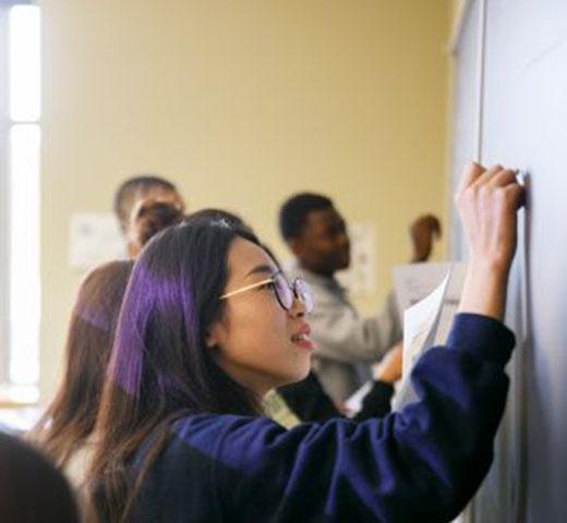 student writing on chalkboard