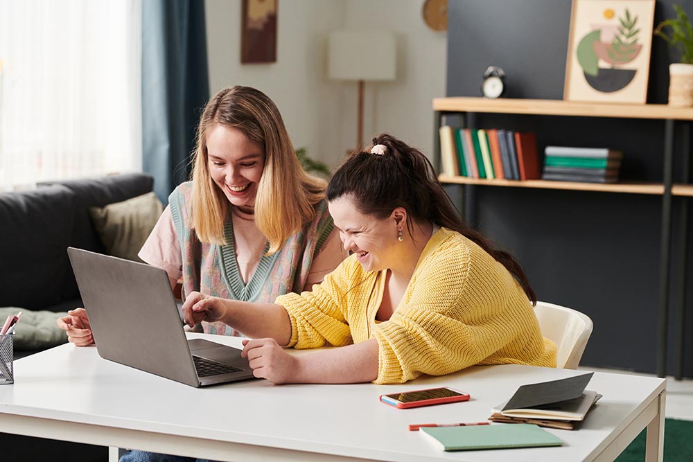 student sits with professor at desk