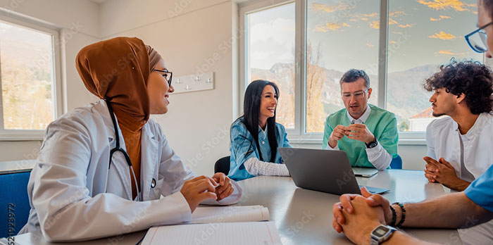 medical professionals sit around a table talking