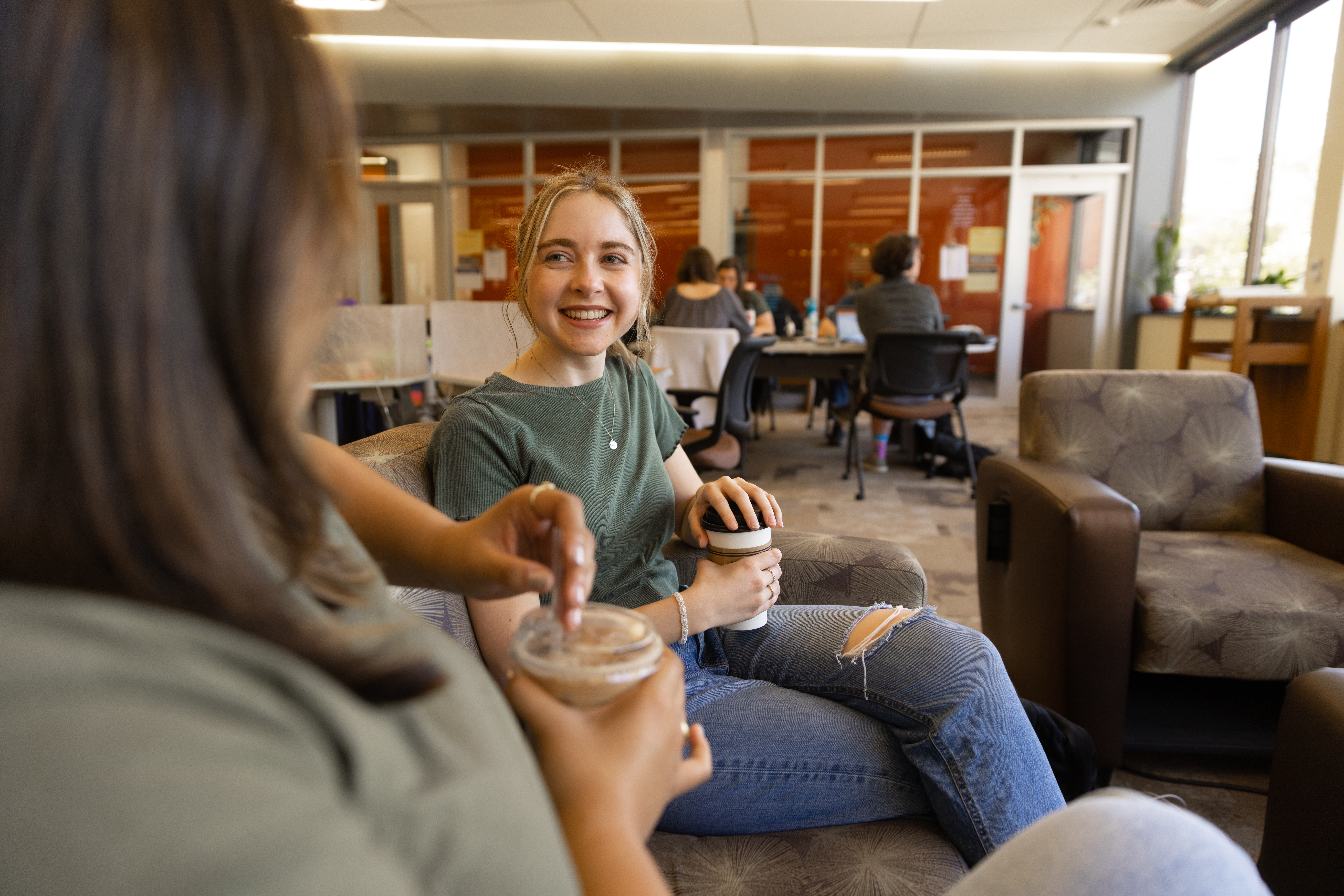 Two students smiling and talking in the Murray Library.