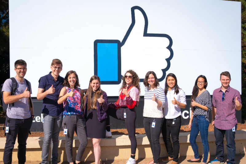 Group of people in front of Facebook building.