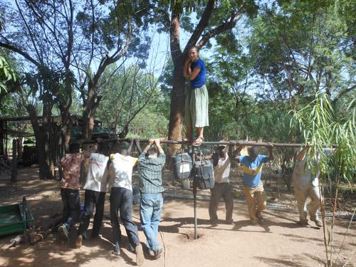 A group of people rotating a man operated drill.