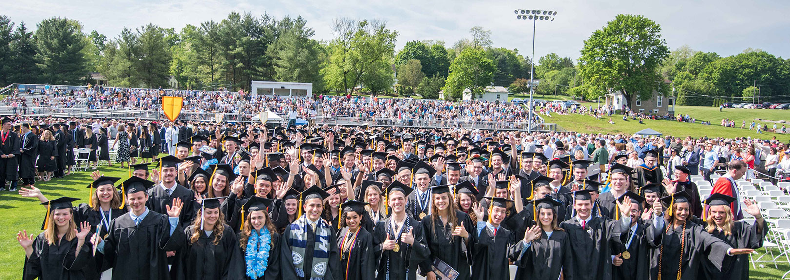 Front row of grads cheering at Commencement