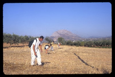 Archaeology students search for artifacts in a desert area.