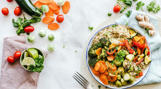 A spread of various vegetables and a salad on a table is shown.