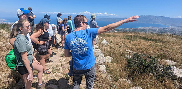 Students and professor in Greece looking over a vast open valley