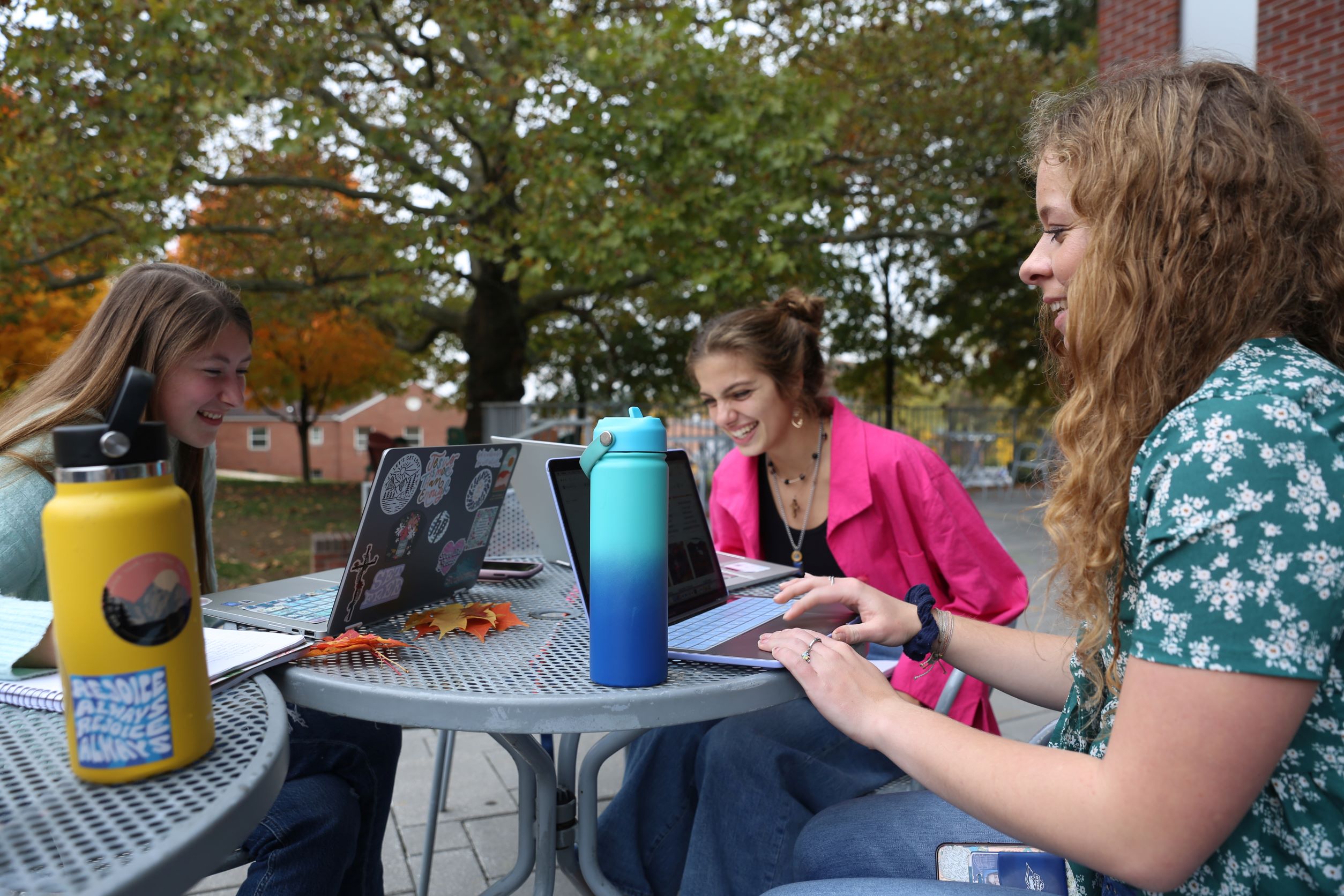 Three Students working outside and studying.