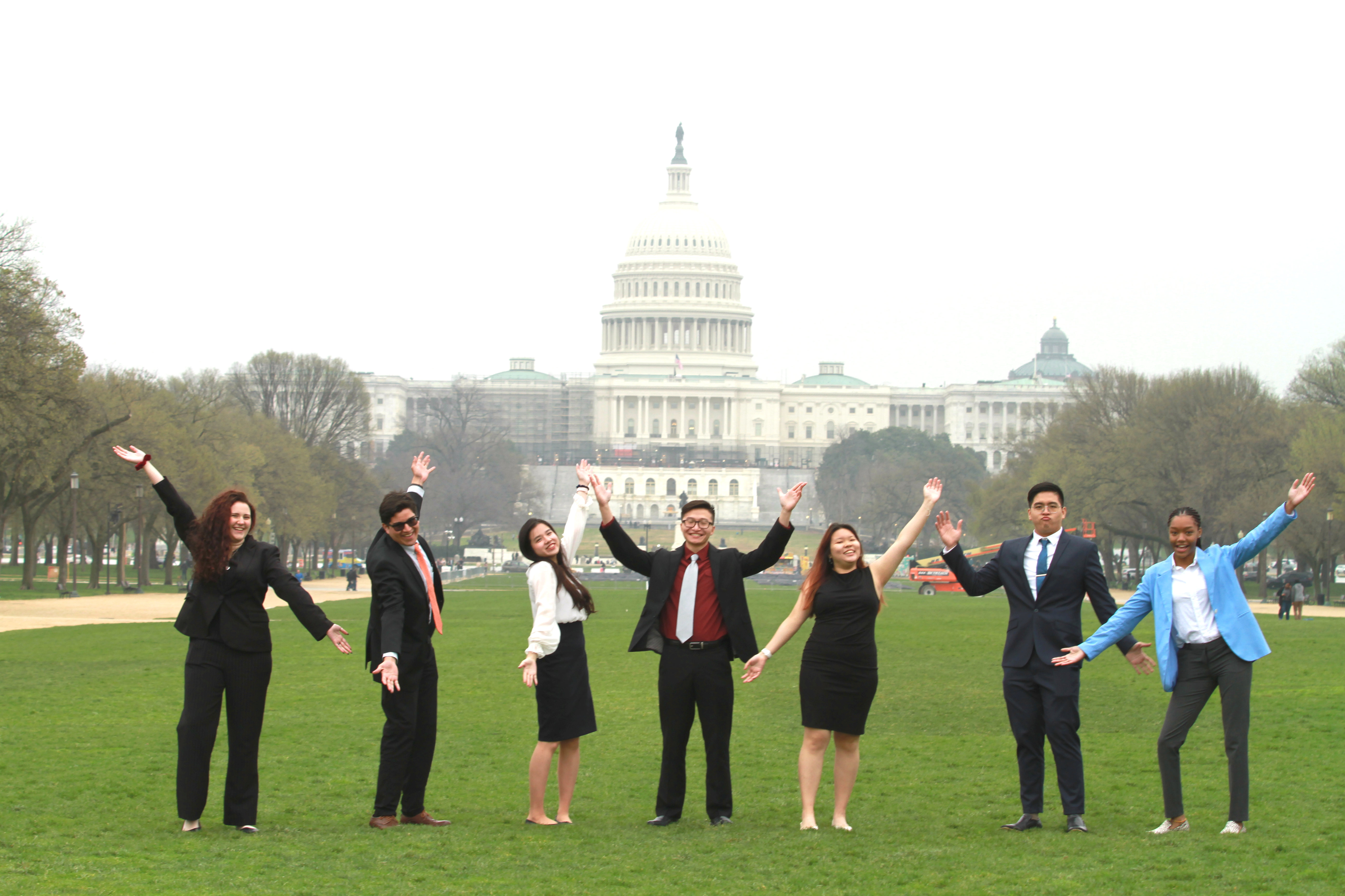 Messiah students posing with their hands up infront of the capital building in Washington DC