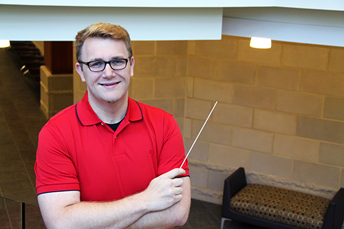 Jared Daubert holding a conducting baton.