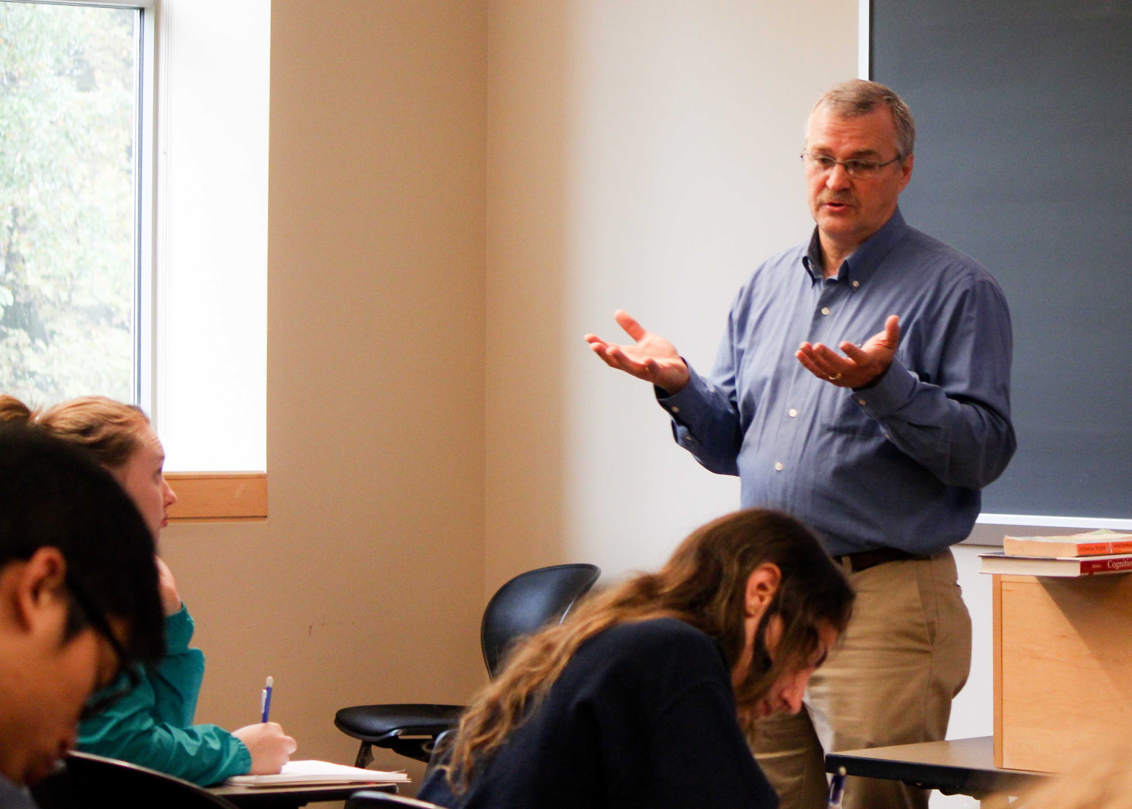 Professor teaching in classroom with several students