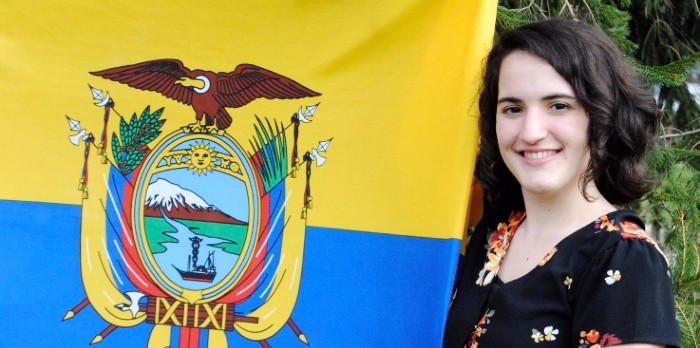 Marissa Donlevie stands beside flag of Ecuador