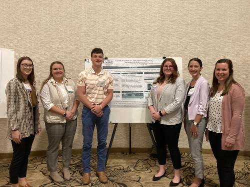 Nursing students standing at their poster during the Wellspan conference.