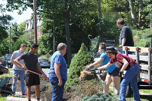 Volunteers from Agape Center shoveling ground for service.