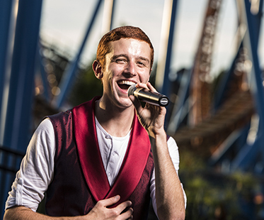 Joel Bauman singing into a mic.