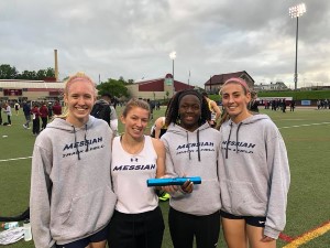 Four women on a relay team stand together with a trophy.