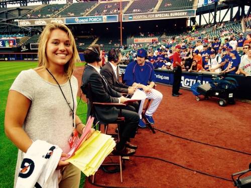 A female student interning at a baseball game.