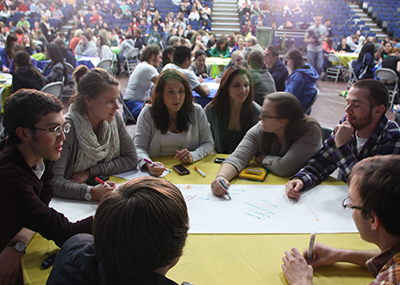 Students gathered around a table, working through topic