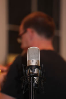 A man's silhouette behind a mic.